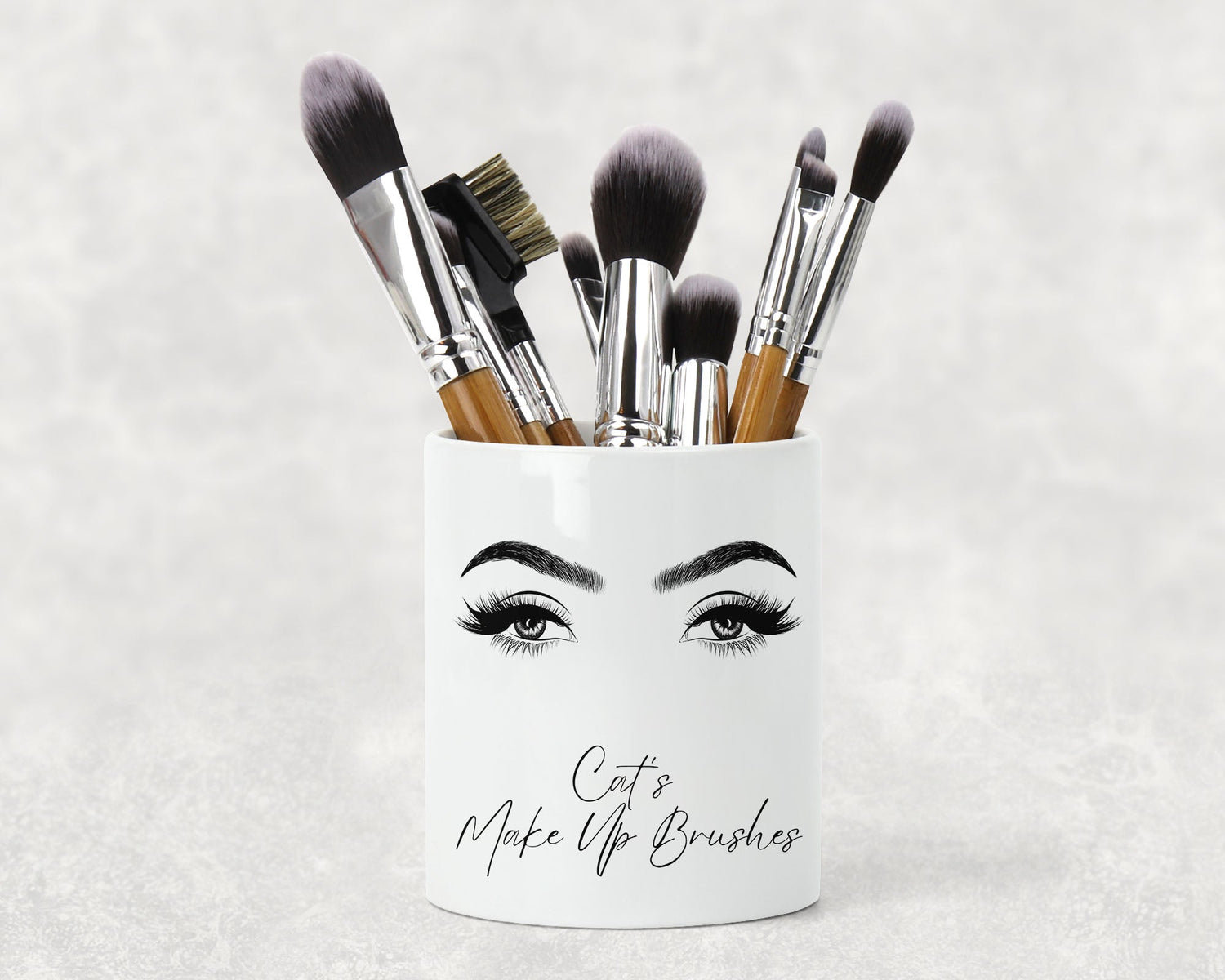 White makeupbrush holder with Eyebrows and Eye's reading the words Cat's Make Up Brushes