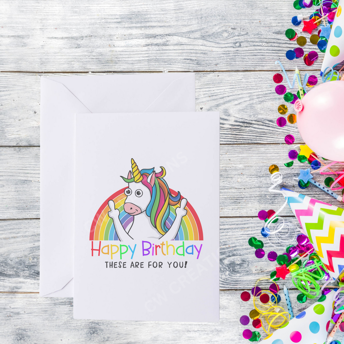 White card with bright colours a unicorn standing in front of rainbow sticking middle fingers up. Reading the words Happy Birthday These Are For You!