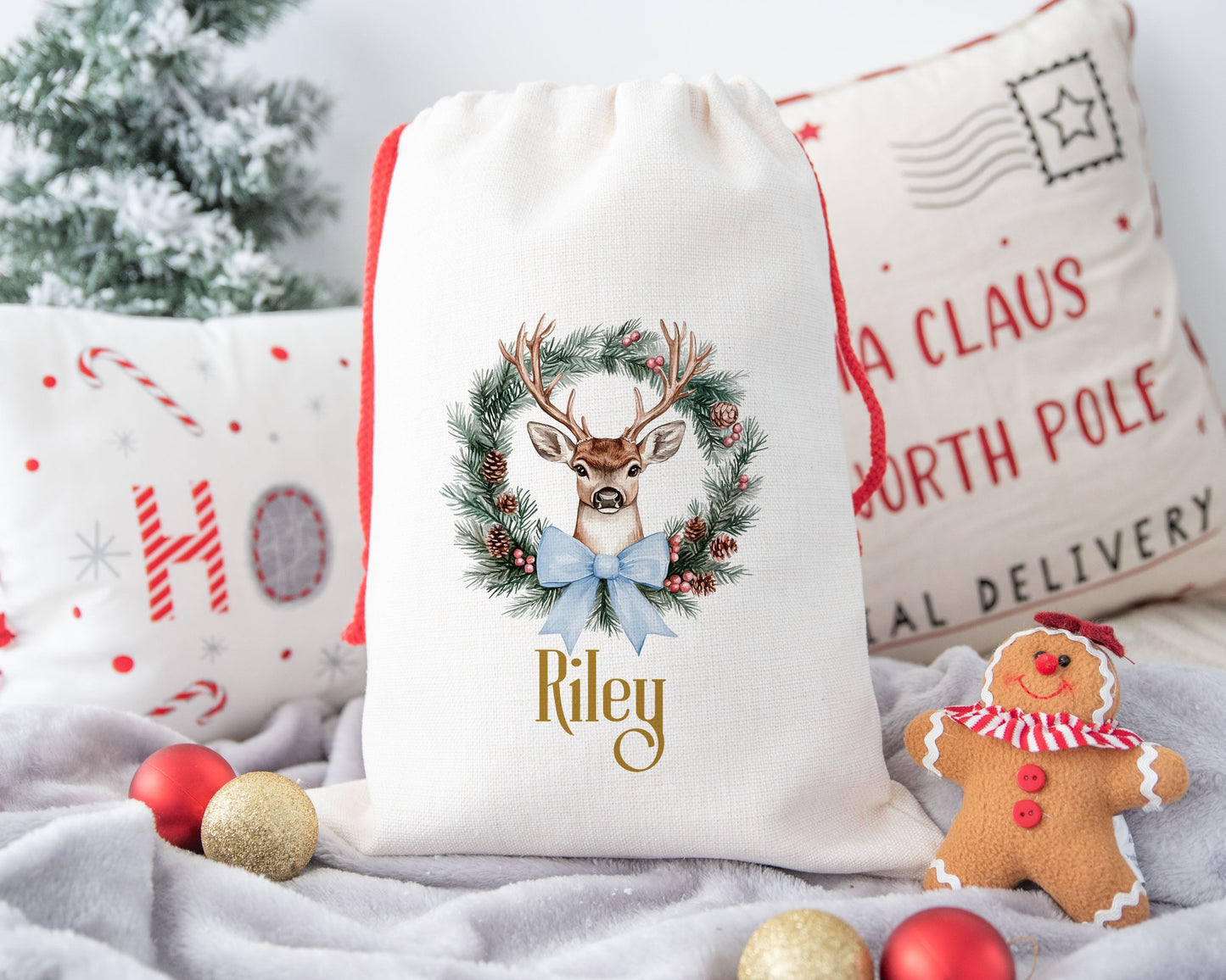 A linen Christmas sack with a Reindeer Wreath with a blue ribbon personalised with a name