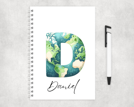 A white notebook with the letter D graphic of the earth personalised with a childs name.