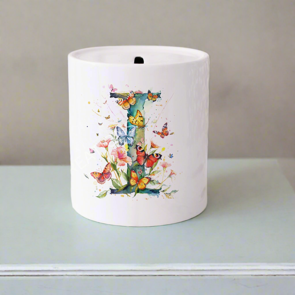 A white floral moneybox with a capital letter I covered in butterflies and flowers