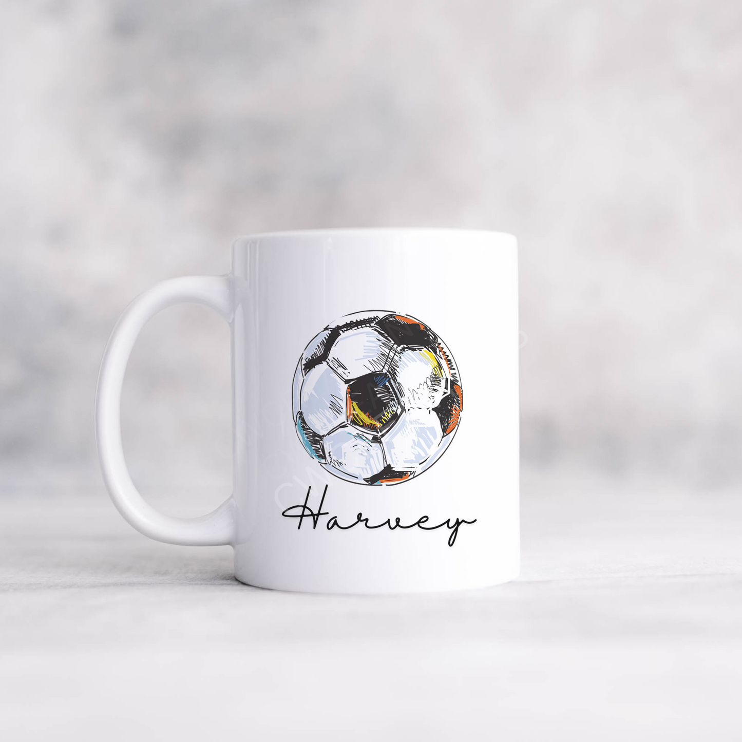 A white mug with a football graphic personalised with a name.