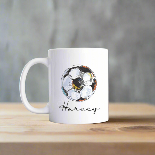 A white mug with a football graphic personalised with a name.