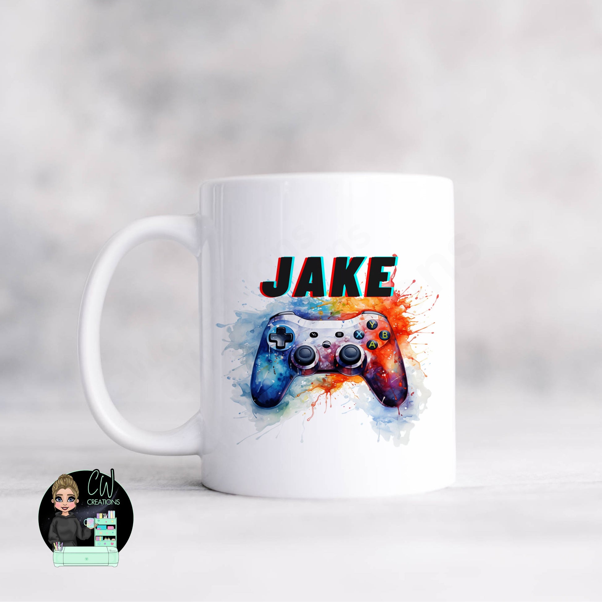 A white mug with a gaming controller on splashes of paint personalised with a name.