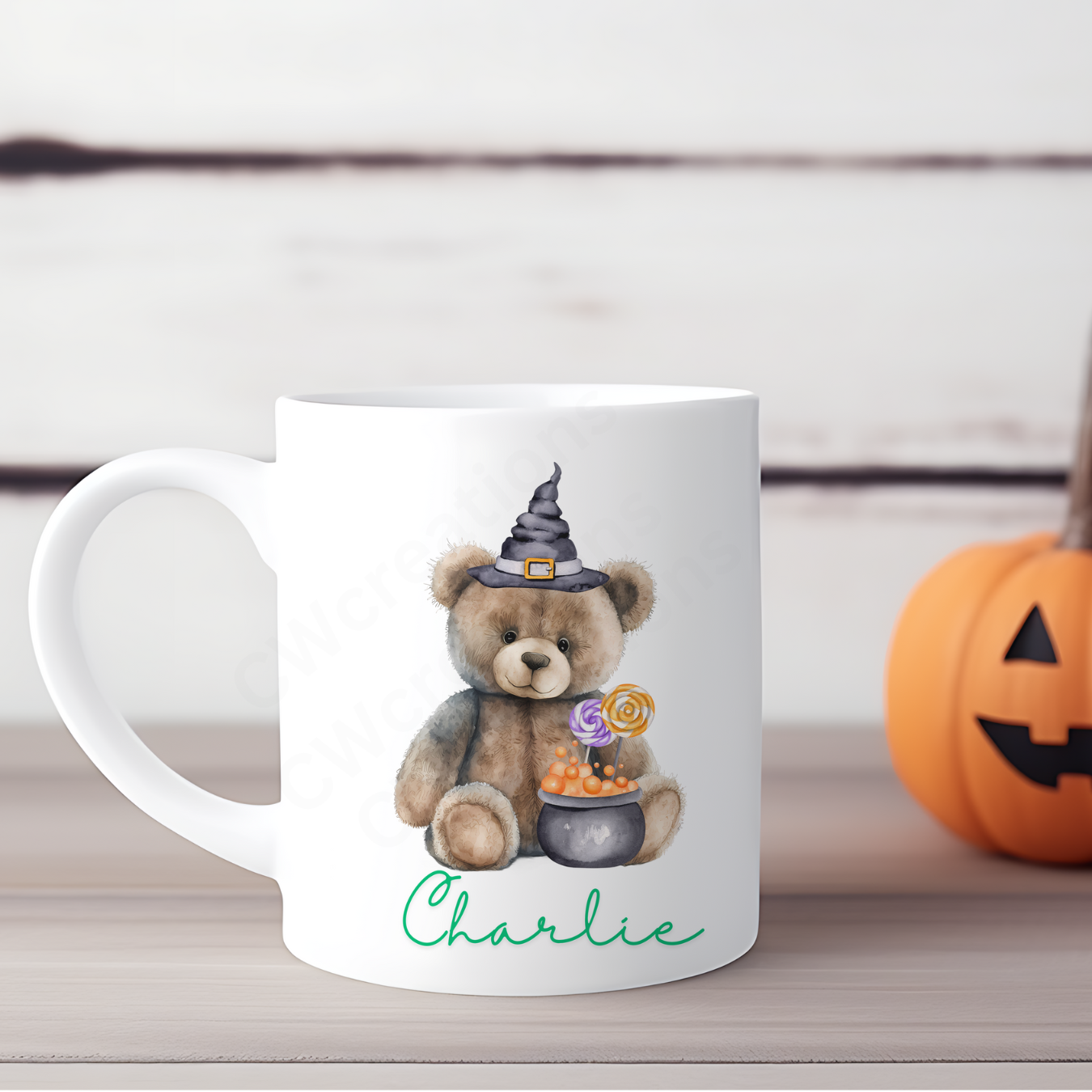 A white mug with a Teddy wearing a witches hat  and cauldron personalised with a childs name.