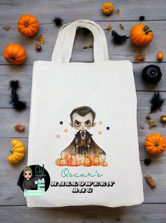 A white bag with a vampire pumpkin and stars personalised with a name with the words Halloween bag.