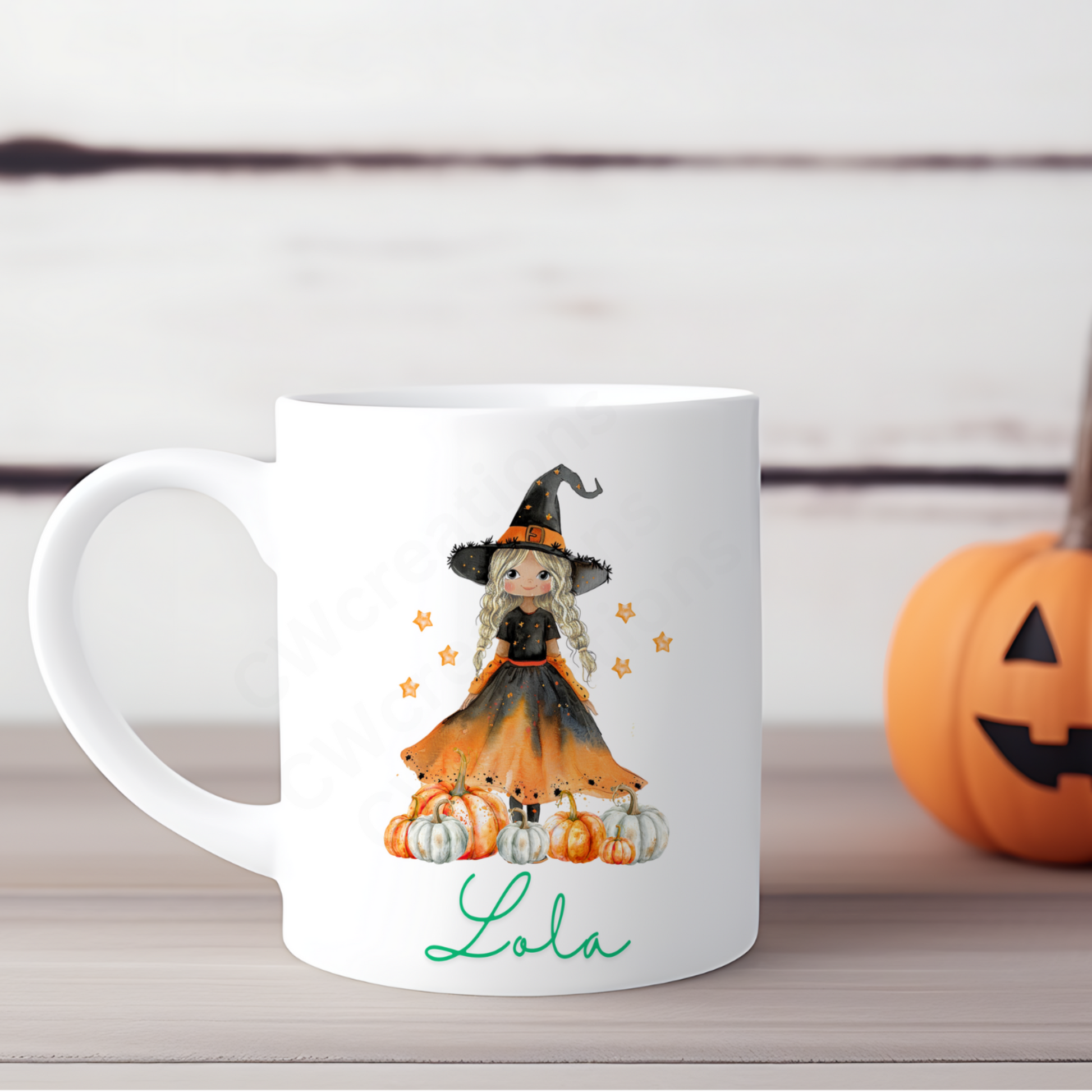 A white mug with a witch pumpkin and stars personalised with a name.