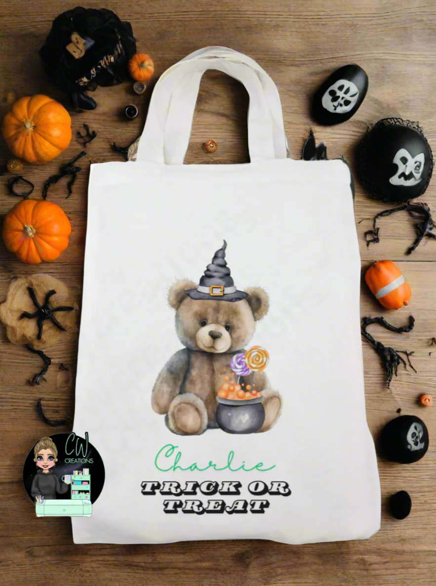 A white bag with a bear wearing a witches hat infront of a cauldron.