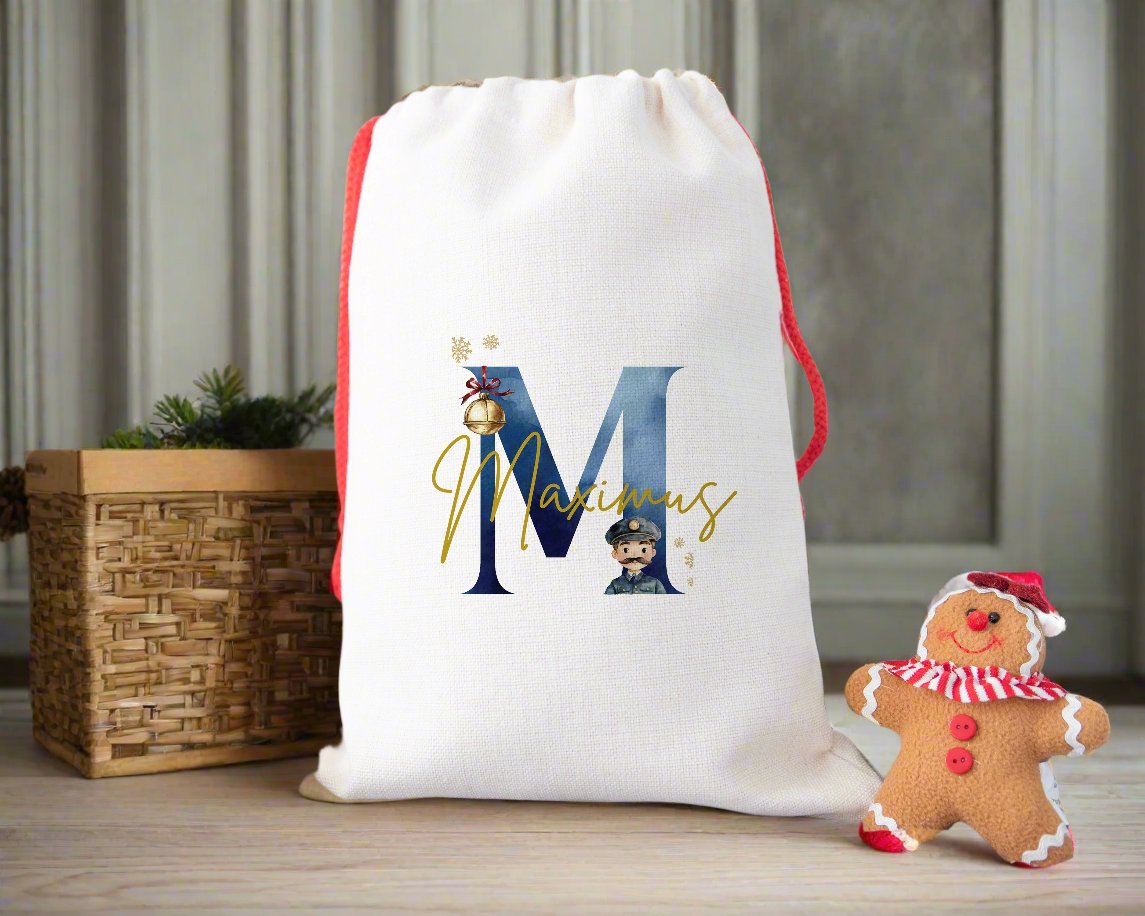 A linen Christmas sack personalised with a initial and a name with the image of a bell and a train conductor.