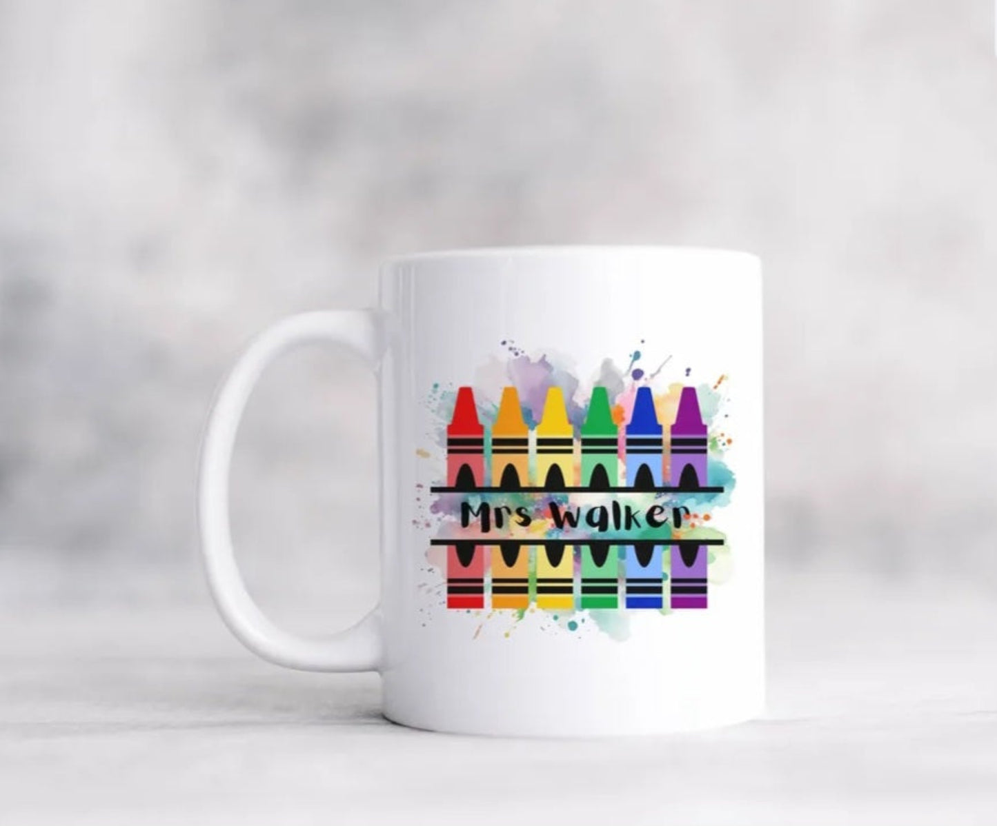 A white mug with paint splashes crayons personalised with a teachers name