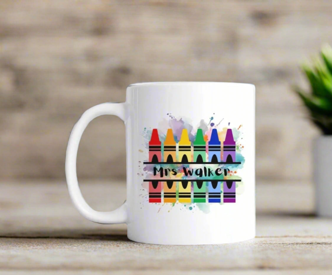 A white mug with paint splashes crayons personalised with a teachers name