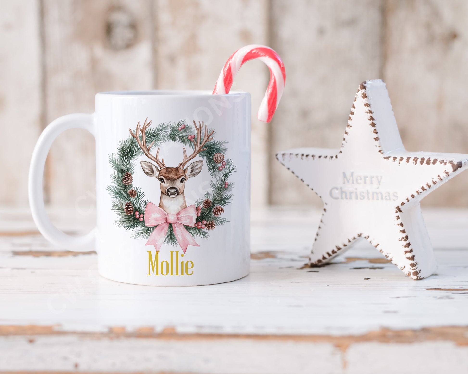 A festive Christmas mug featuring a reindeer design surrounded by a decorative wreath.