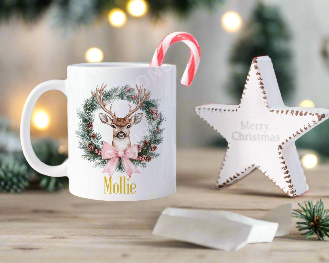 A festive Christmas mug featuring a reindeer design surrounded by a decorative wreath.