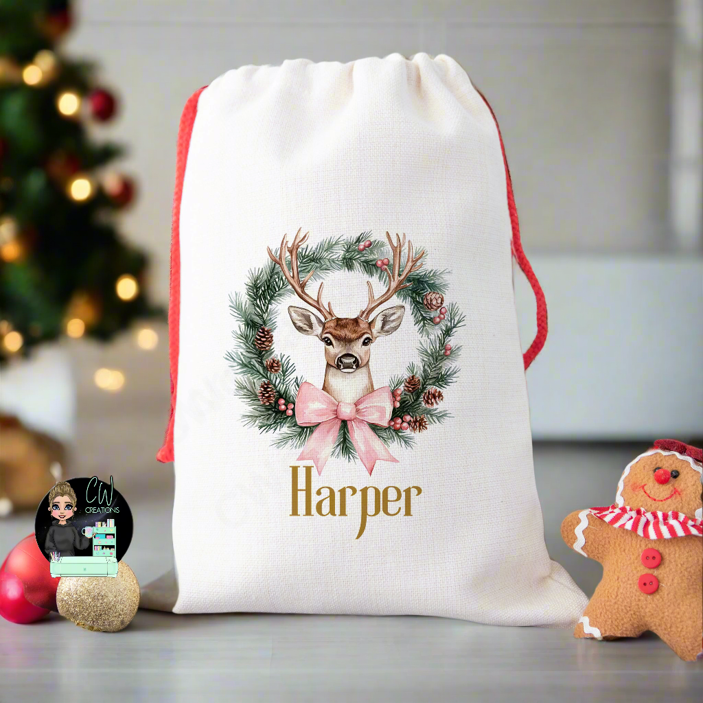 A linen Christmas sack with a Reindeer Wreath with a blue ribbon personalised with a name